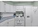 White appliances and cabinets with gas range in a kitchen with light blue countertop at 1033 Scotch Pine Ct, Leesburg, FL 34788