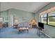 Open concept living room with a sofa, side tables, and a view into the dining area with plenty of light at 1033 Scotch Pine Ct, Leesburg, FL 34788