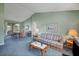 Spacious living room with carpet, natural light, and an open layout connecting to the dining area, perfect for entertaining at 1033 Scotch Pine Ct, Leesburg, FL 34788