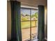 A view from inside showcases a balcony overlooking community greenery, inviting relaxation and creating a seamless indoor-outdoor connection at 1051 S Highland St # 7E, Mount Dora, FL 32757