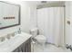 Clean bathroom features a stylish vanity, toilet, and shower with curtain at 1051 S Highland St # 7E, Mount Dora, FL 32757