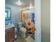 Cozy bathroom featuring a toilet, vanity, and decorative shower curtain, creating a functional and inviting space for daily routines at 1051 S Highland St # 7E, Mount Dora, FL 32757
