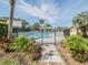 Fenced in community pool with chairs and palm trees at 1051 S Highland St # 7E, Mount Dora, FL 32757