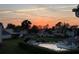 Community pool surrounded by lush landscaping and neighborhood homes at sunset at 1051 S Highland St # 7E, Mount Dora, FL 32757