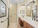 Bathroom features a double sink vanity with framed mirrors and a glass enclosed shower at 10929 Se 167Th Pl, Summerfield, FL 34491