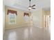 Light-filled bedroom features tile floors, ceiling fan, neutral walls, and access to an en-suite bathroom at 10929 Se 167Th Pl, Summerfield, FL 34491