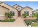 Beautiful home featuring manicured landscaping, a welcoming entryway, and a red front door at 10929 Se 167Th Pl, Summerfield, FL 34491