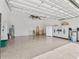 Spacious garage with epoxy flooring and ample storage, including shelving and cabinets at 10929 Se 167Th Pl, Summerfield, FL 34491