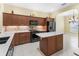 The kitchen includes a center island, stone countertops, stainless steel appliances, and wooden cabinets at 10929 Se 167Th Pl, Summerfield, FL 34491