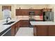 This open concept kitchen features stone countertops, stainless steel appliances, and wooden cabinets at 10929 Se 167Th Pl, Summerfield, FL 34491