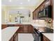 Bright and functional kitchen with stainless steel appliances, solid countertops, and dark cabinets at 10929 Se 167Th Pl, Summerfield, FL 34491