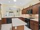 Well-appointed kitchen with an island, black appliances, and dark wood cabinetry at 10929 Se 167Th Pl, Summerfield, FL 34491