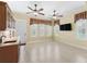 A living room features a bar area, tile floors, base molding, and plantation shutters on the windows at 10929 Se 167Th Pl, Summerfield, FL 34491