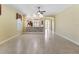 A sun-filled living room has an open layout, stone floors, base molding, and views into the kitchen at 10929 Se 167Th Pl, Summerfield, FL 34491