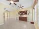 A stunning living room features a stone floor, a built-in bar, and views of the kitchen and dining area at 10929 Se 167Th Pl, Summerfield, FL 34491