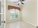 Bright office space featuring tile floors, ceiling fan, and large window with custom valance at 10929 Se 167Th Pl, Summerfield, FL 34491