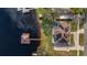 Aerial view showcasing a lakefront property with a private dock, pool, and solar panels at 11007 Lake Katherine Cir, Clermont, FL 34711