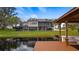 Home's backyard featuring a private dock, screened patio, lush green lawn, and waterfront views at 11007 Lake Katherine Cir, Clermont, FL 34711