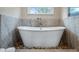 Bathroom showcasing a luxurious soaking tub on a bed of rocks under a bright window at 11007 Lake Katherine Cir, Clermont, FL 34711