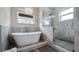 Bathroom featuring a soaking tub on a bed of rocks and a frameless glass shower with marble surround at 11007 Lake Katherine Cir, Clermont, FL 34711