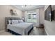 Bedroom with gray headboard, ceiling fan, and a sun-filled window overlooking the front yard at 11007 Lake Katherine Cir, Clermont, FL 34711