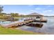 Beautiful boat dock on the lake with a boat lift and covered structure for relaxing and enjoying the water at 11007 Lake Katherine Cir, Clermont, FL 34711