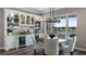 A stylish dining room showcases custom cabinetry, a sleek chandelier, and a picturesque view of the lake at 11007 Lake Katherine Cir, Clermont, FL 34711