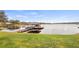 View of a private dock with a covered boat lift on a serene lake with lush green surroundings at 11007 Lake Katherine Cir, Clermont, FL 34711