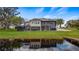 Waterfront backyard featuring a private dock, screened patio, lush green lawn, and serene water views at 11007 Lake Katherine Cir, Clermont, FL 34711