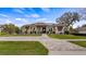 Charming single-story home with a brick driveway, well-manicured lawn, and lush landscaping, set beneath a bright, partly cloudy sky at 11007 Lake Katherine Cir, Clermont, FL 34711