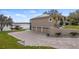 A house showcasing a spacious three-car garage and a paved driveway leading to the waterfront at 11007 Lake Katherine Cir, Clermont, FL 34711