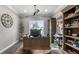 A well-lit home office with built-in shelving, a large window, and a spacious desk at 11007 Lake Katherine Cir, Clermont, FL 34711