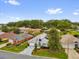Aerial view of home with gray driveway, well manicured lawn and community at 11396 Se 178Th Pl, Summerfield, FL 34491