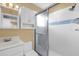 Standard bathroom with a vanity, toilet, and glass-enclosed shower with white and blue tile at 11396 Se 178Th Pl, Summerfield, FL 34491