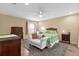 Cozy bedroom with a tropical-themed bedspread, ample natural light, and classic furniture, creating a serene retreat at 11396 Se 178Th Pl, Summerfield, FL 34491