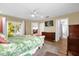Bright bedroom with tropical-themed bedding, access to the outdoors, and a glimpse of the en-suite bathroom at 11396 Se 178Th Pl, Summerfield, FL 34491