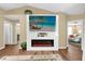 Bright living room with electric fireplace, large TV, and open access to other rooms at 11396 Se 178Th Pl, Summerfield, FL 34491