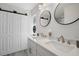 Modern bathroom with a double sink vanity, stylish mirrors, updated fixtures, and a glass-enclosed shower at 11684 Sw 72Nd Cir, Ocala, FL 34476