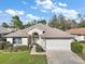 Beautiful single-story home featuring a well-manicured lawn, charming landscaping, and a two-car garage at 11684 Sw 72Nd Cir, Ocala, FL 34476
