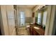 Bathroom featuring granite countertop, warm wood cabinets, and decorative art at 11727 Pineloch Loop, Clermont, FL 34711