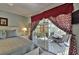 Bedroom with neutral walls and slider door leading to screened lanai with backyard views at 1229 Augustine Dr, The Villages, FL 32159