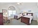 Bedroom with dual beds, sitting chair and ottoman in a bright space with vaulted ceilings at 1229 Augustine Dr, The Villages, FL 32159