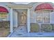 Charming front entrance with red awnings over the windows and decorative landscaping at 1229 Augustine Dr, The Villages, FL 32159