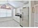 Bright kitchen with stainless steel refrigerator, white cabinetry, and dark countertops at 1229 Augustine Dr, The Villages, FL 32159