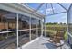 Screened in lanai with rocking chair and view of sprawling backyard at 1229 Augustine Dr, The Villages, FL 32159
