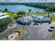 Aerial view features a large lake, blue swimming pool, community buildings, and a large parking lot at 1340 Elkhart Cir, Tavares, FL 32778
