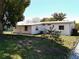 Backyard view with lush greenery, trees, and the home's exterior featuring a metal roof at 1340 Elkhart Cir, Tavares, FL 32778