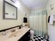 Bathroom featuring patterned shower curtain, checkerboard flooring, and a black vanity at 1340 Elkhart Cir, Tavares, FL 32778