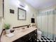 Bathroom featuring patterned shower curtain, checkerboard flooring, and a black vanity at 1340 Elkhart Cir, Tavares, FL 32778