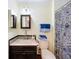 Cozy bathroom showcasing a sink, mirror, and toilet with patterned shower curtain at 1340 Elkhart Cir, Tavares, FL 32778